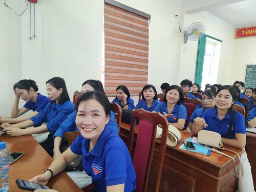 A group of people in blue shirts sitting at a desk

Description automatically generated